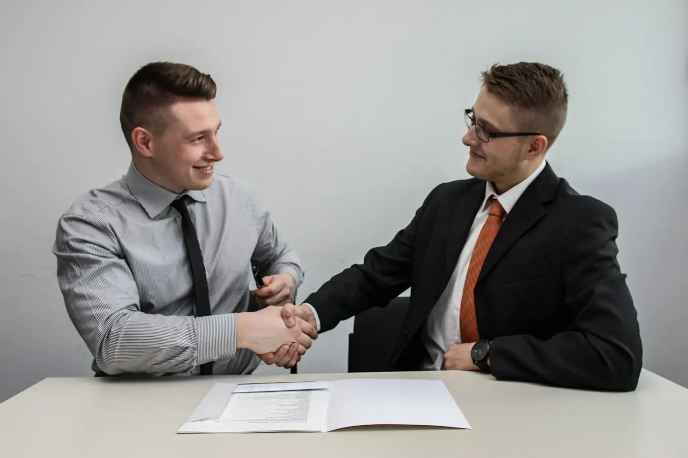 Duas pessoas apertando as mãos após fechar um contrato