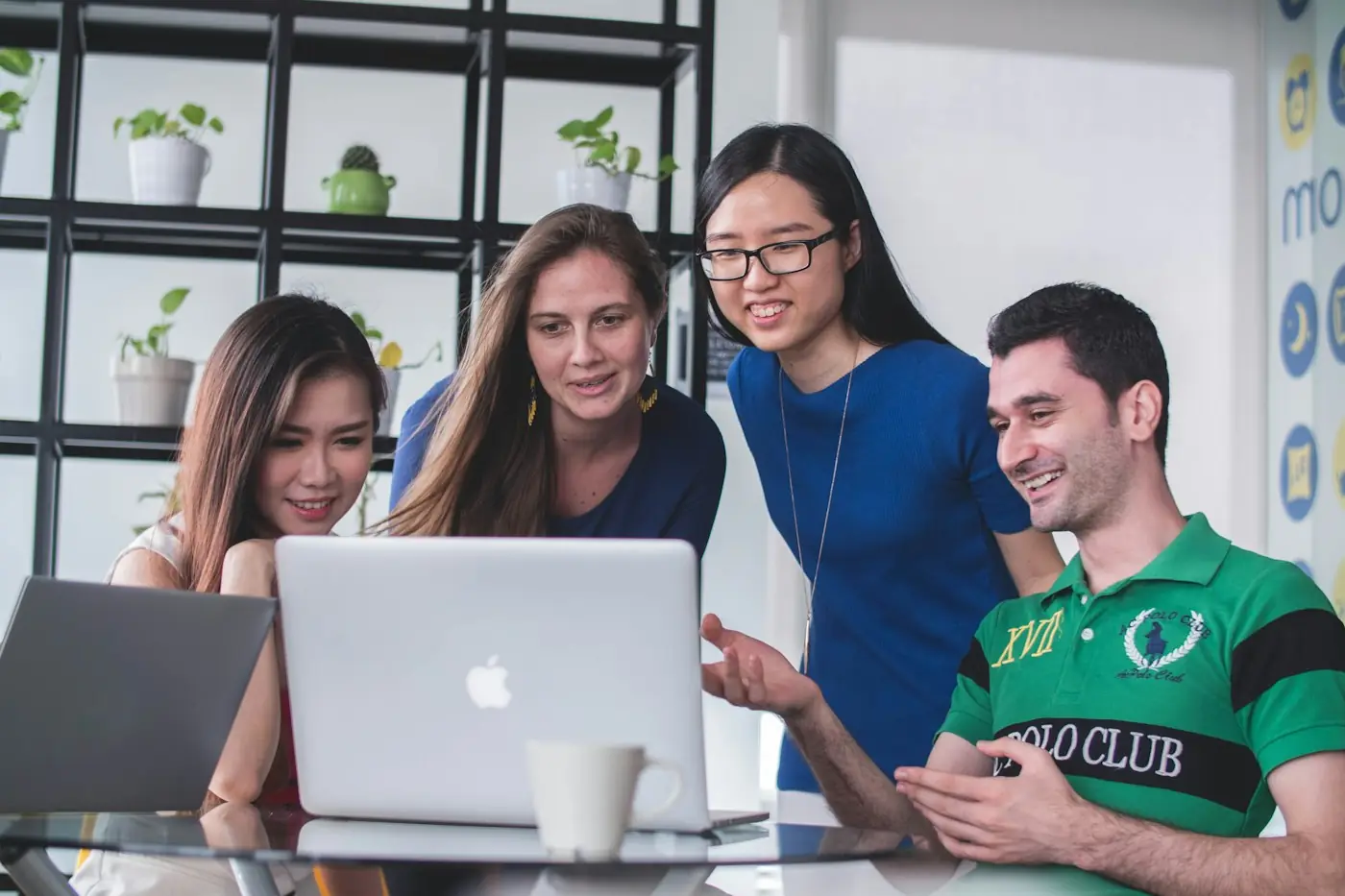 Equipe comercial reunida em volta de um notebook analisando o funil de vendas