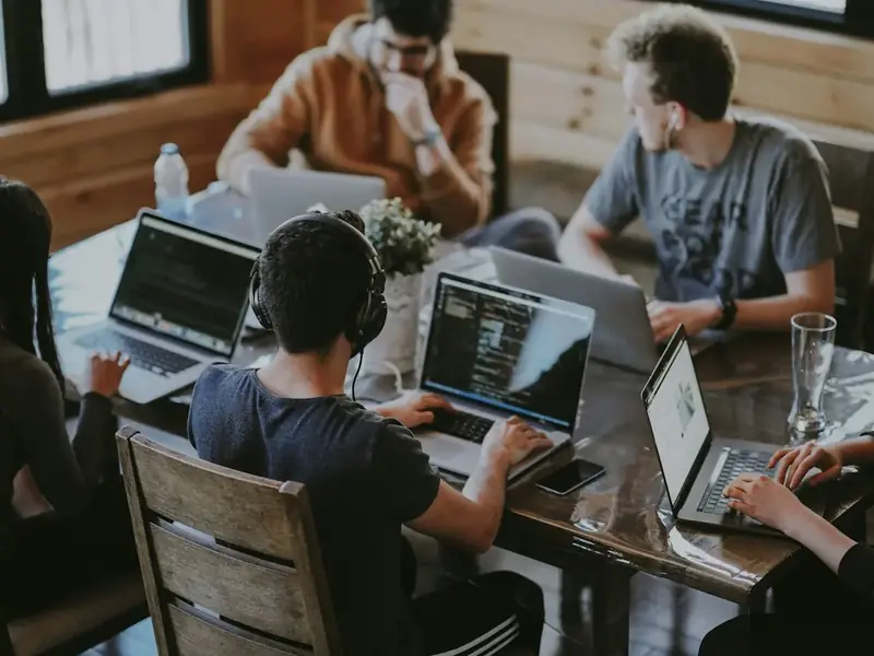 Equipe atendendo junta em notebooks no escritório