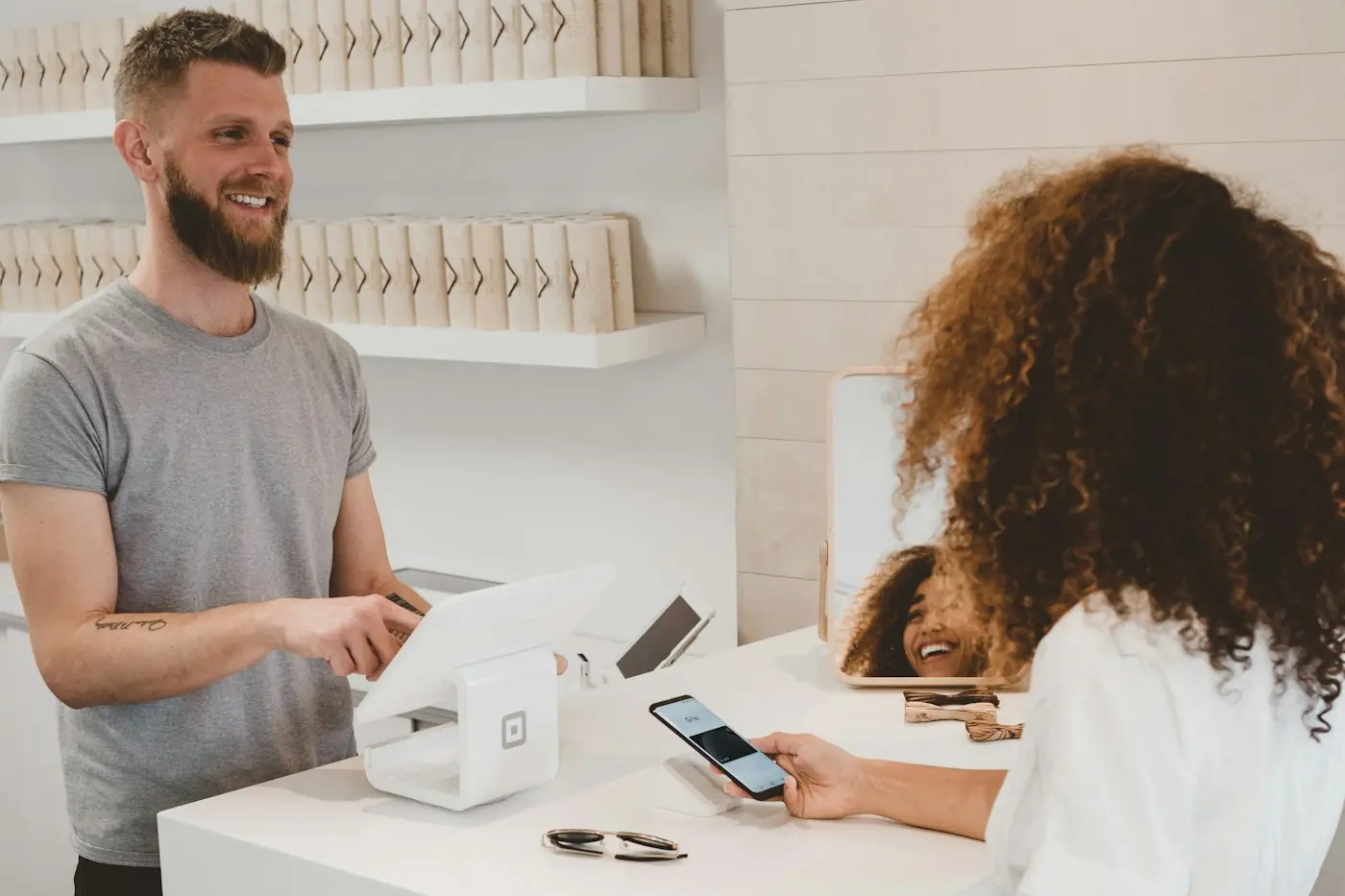 Cliente pagando pelo celular no balcão de uma loja