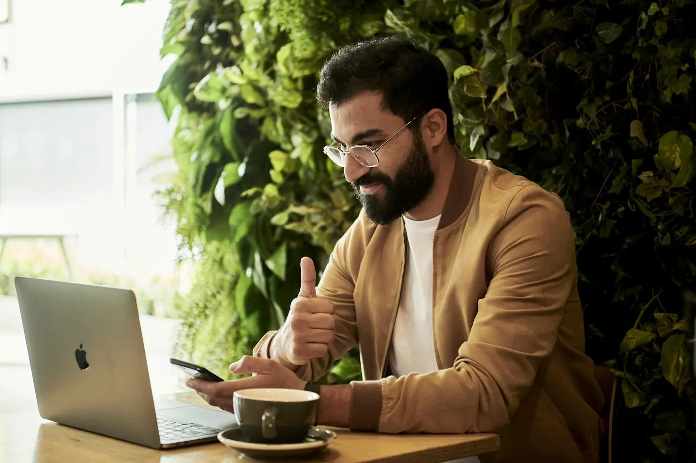 Empresário usando o celular e o notebook para atender clientes